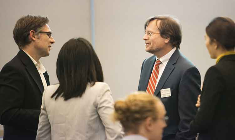 A diverse group of professionals engaged in conversation at a business networking event.