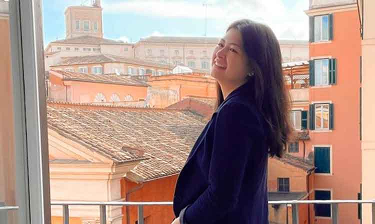 A student stands on a balcony in Florence.