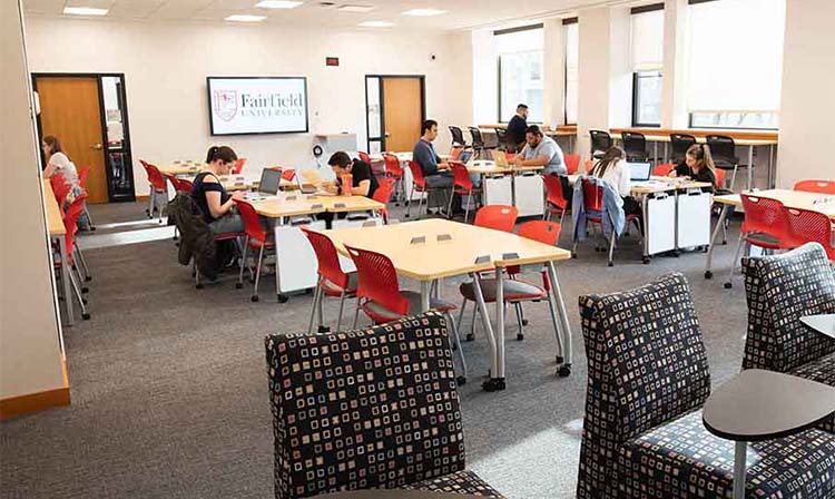Image of a large room featuring multiple tables and chairs, ideal for events or group activities.