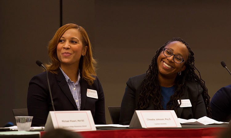 Deans Dialogue Series panelists smile on the stage.