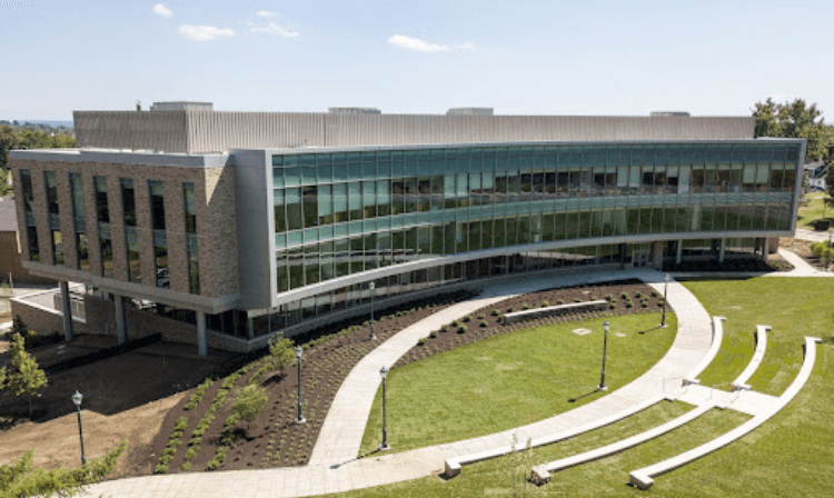 Exterior shot of dolan school of business sign in front of building.