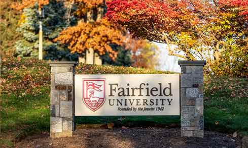 Fairfield University campus sign held up between two stone pillars.