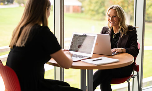 Two students working on a table. 