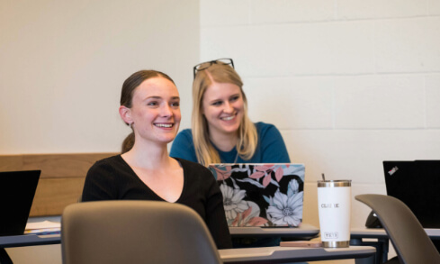 Two SEHD students sit in a classroom.