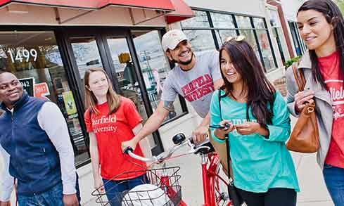A group of students walk outside of the Fairfield University Bookstore.