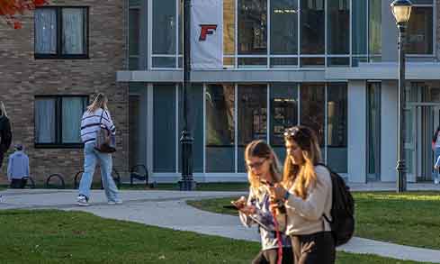 Two students walk together outdoors.