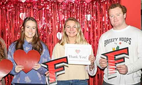 Three students pose with cut out Fairfield signs.