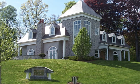 Exterior shot of the gray-brick Alumni House building.