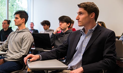 Students sitting in an intimate classroom setting as they listen to a lecture about applied math.