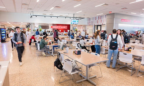 Students in the busy, brightly-lit Tully dining hall, filled with plenty of seating and dining options.