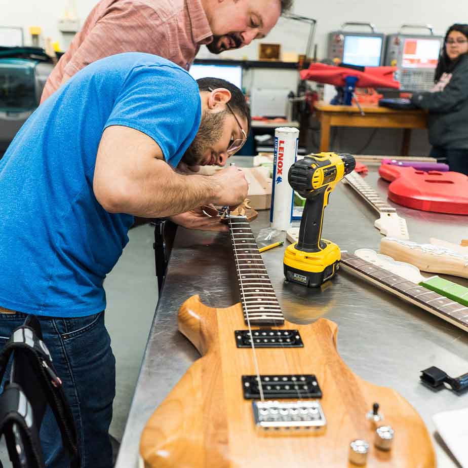 Electrical engineering students building an electric guitar.
