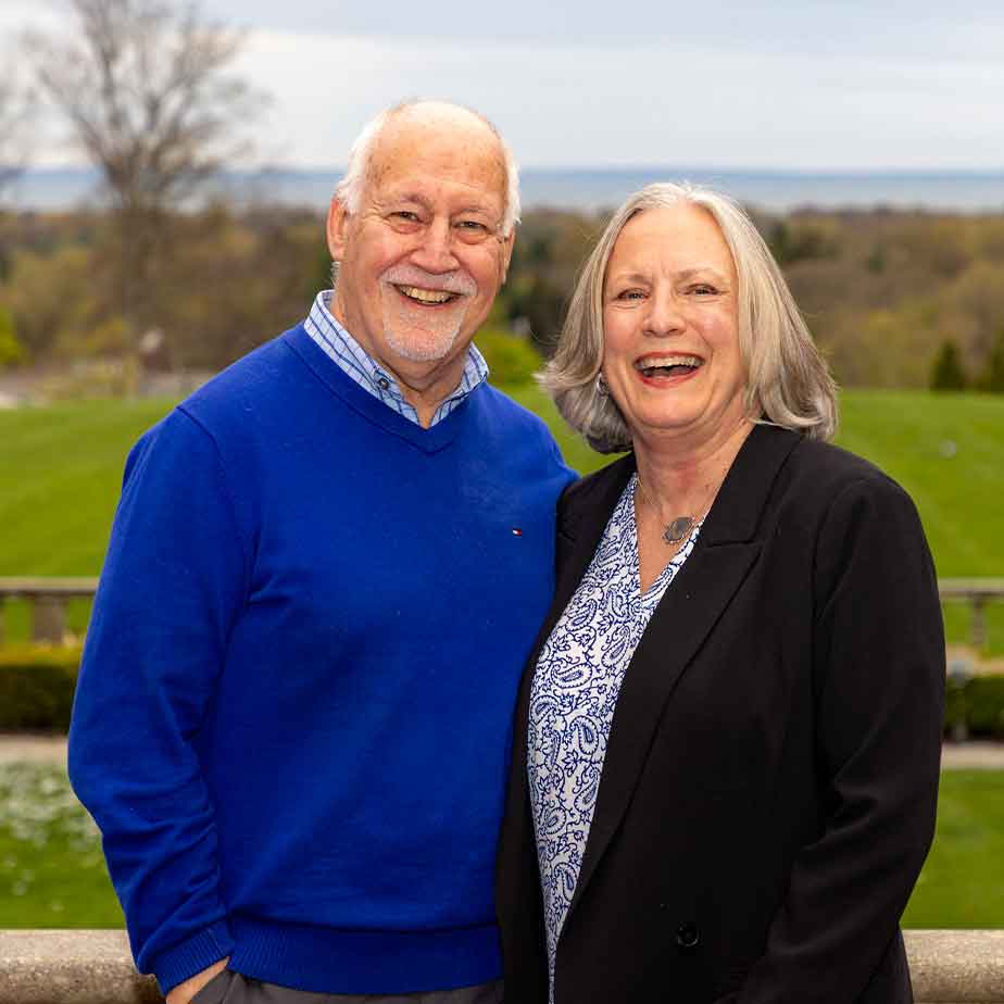 A happy couple poses for a photo with Bellarmine Lawn behind them.