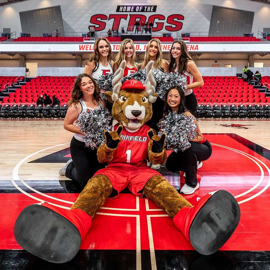 The Stag mascot stands cheering in front of Fairfield’s cheerleaders.