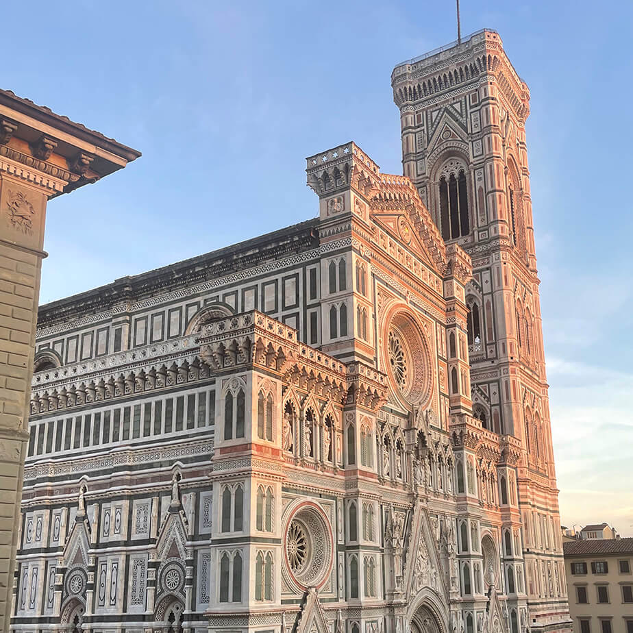 Exterior shot of the marble and brick facade of the Florence Cathedral.