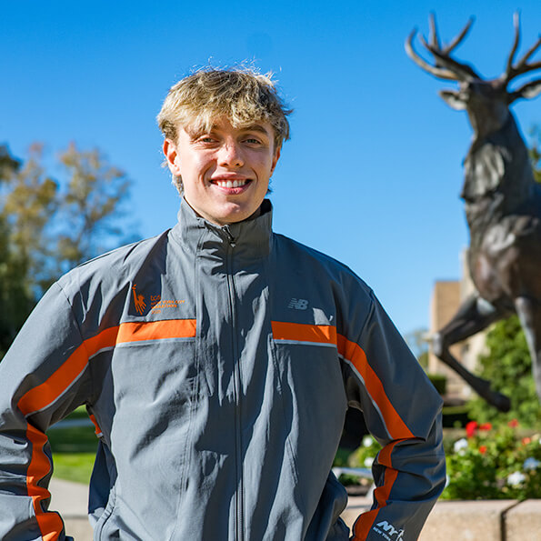A student dressed in a stylish jacket stands confidently, showcasing a modern and fashionable look.