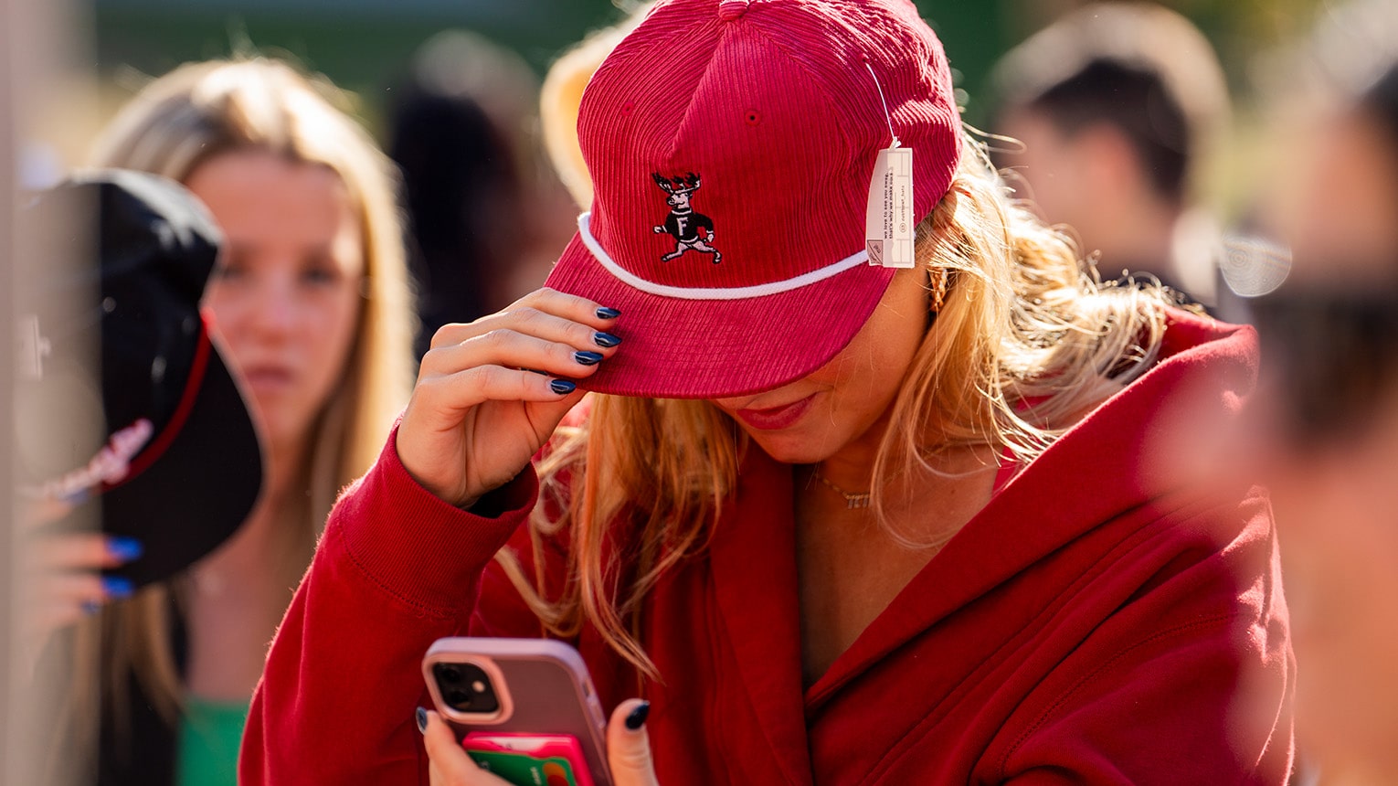 Fairfield student holding her vintage Stags hat as she snaps a selfie for social.