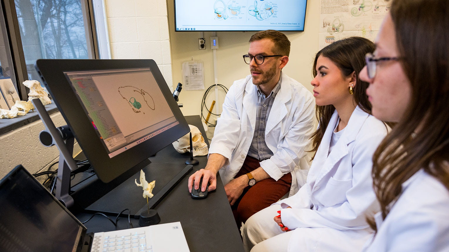 Students getting a hands-on learning opportunity with a professor by studying and observing a 3D rendering of the inner ear of a human.