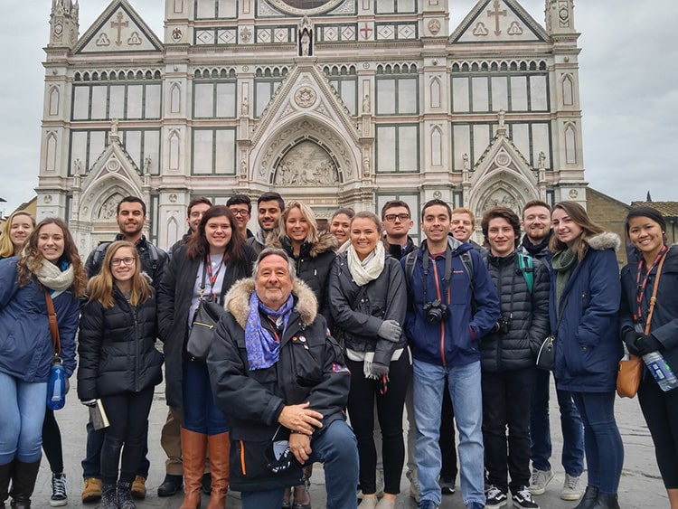 Fairfield professor kneeling and posing in front of the Cathedral of Santa Maria del Fiore with his winter students.
