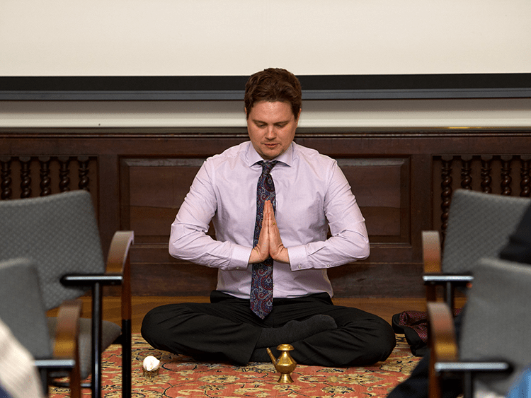 Professor sitting and meditating cross-legged as part of the two-day 'Tantra and Buddhist Ritual in South Asia' symposium.