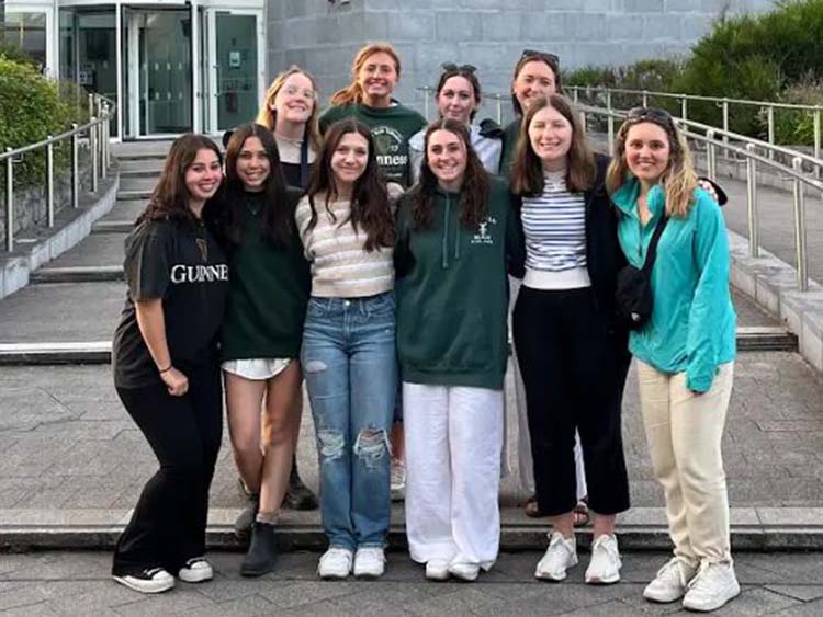 Fairfield psychology students posing excitedly in front of an Irish classroom and research building.