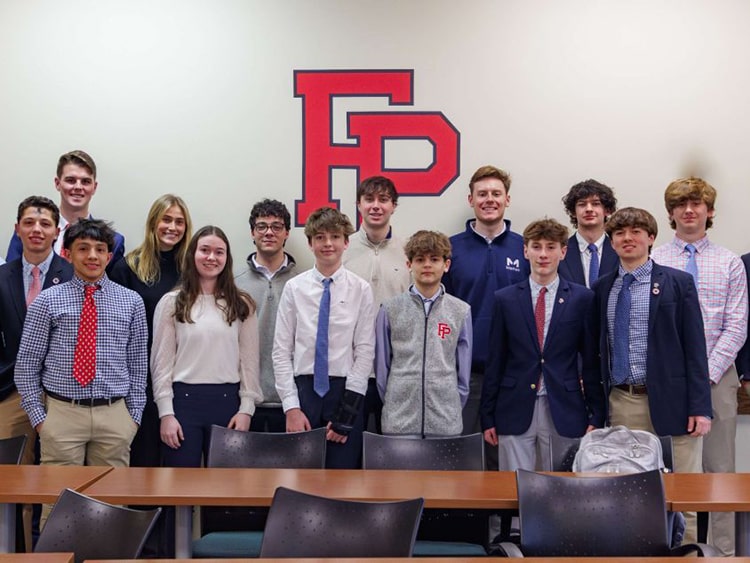Young Fairfield Prep students standing together in business attire clothing.