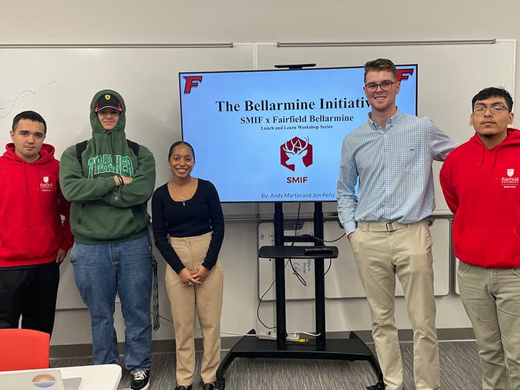 Business students posing as a group before they give their lunch-n-learn presentation on the collaborative efforts between Fairfield Dolan and Fairfield Bellarmine.
