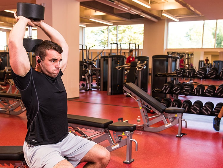 Student-athlete doing free weight training in the recreation complex's weight room.