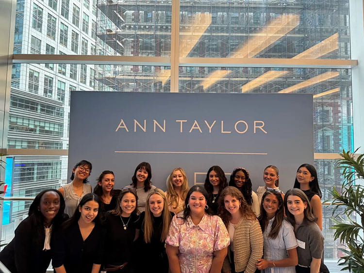 Fairfield Meditz students in front of the Ann Taylor headquarters' namesake sign during an immersive trip to a potential internship company.