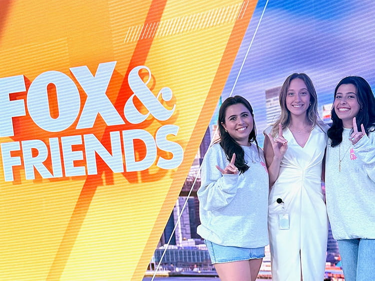Two Fairfield student entrepreneurs posing with fellow classmate and current intern in front of the Fox & Friends virtual news background.