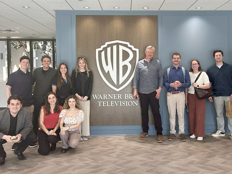Fairfield Meditz students and professor pose with the Warner Bros. wall sign while on an immersive spring break trip in Los Angeles.