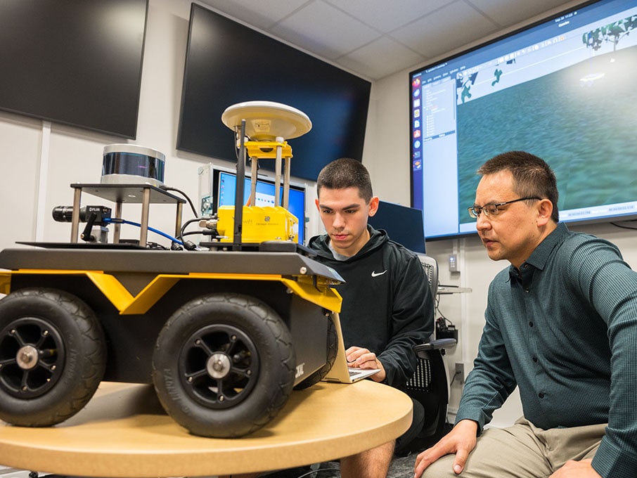Dr. Paheding and student programming Jackal, the Unmanned Ground Vehicle.