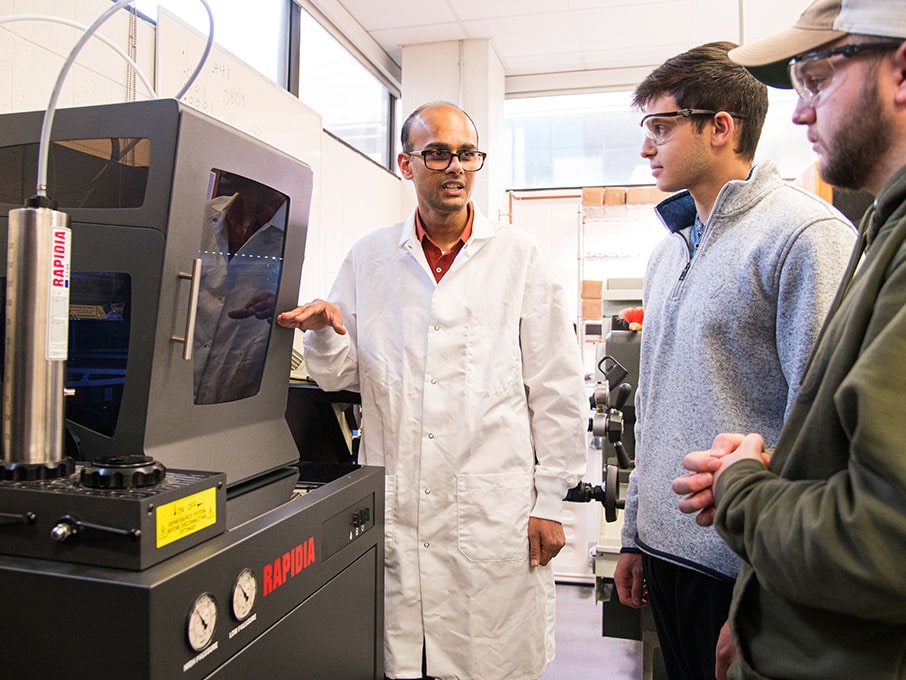 Engineering professor and students using the new 3D printer, Rapida Conflux.