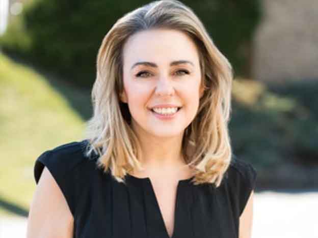 Evelyn Bilias Lolis, PhD Dean Associate Professor headshot with green grass in background.