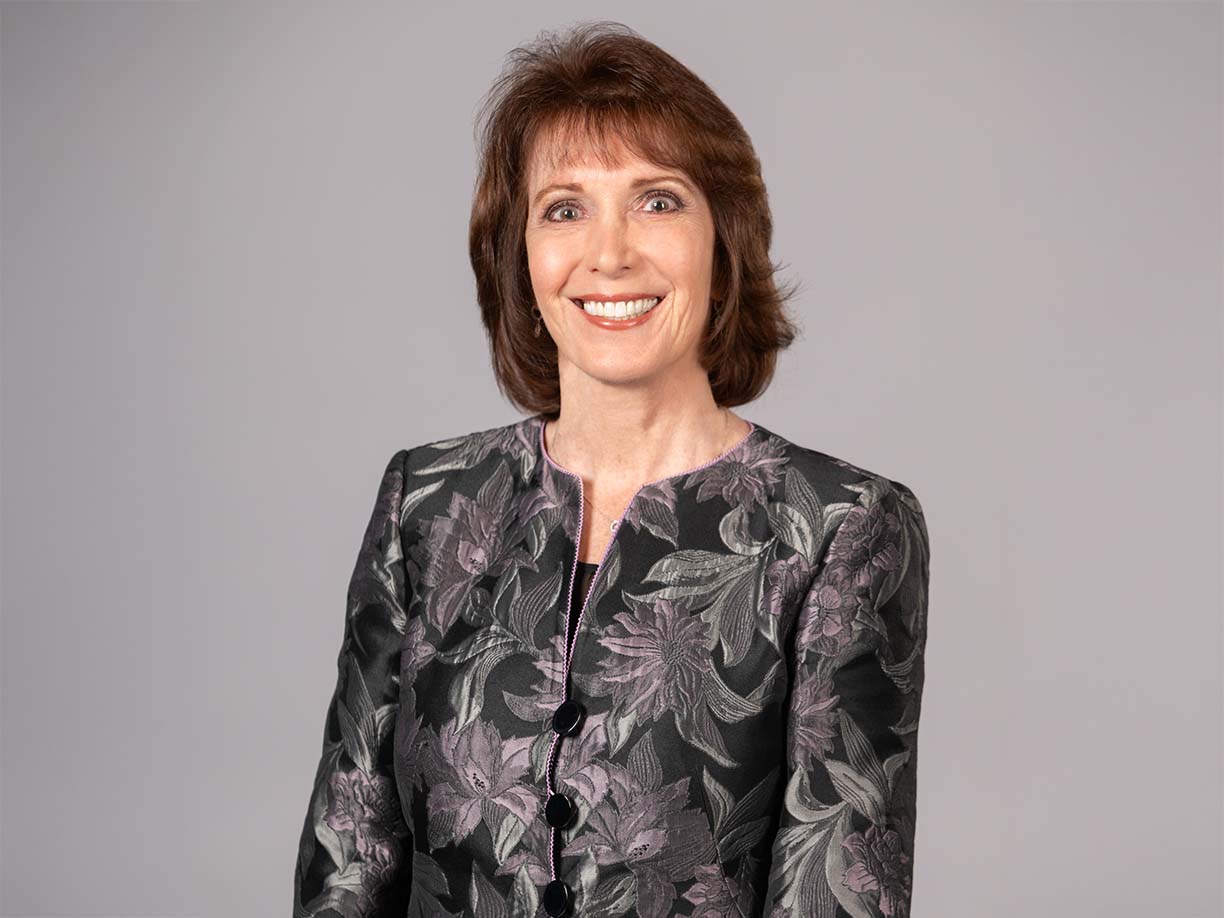 Headshot of Patricia Simino Boyce standing in front of beige background.