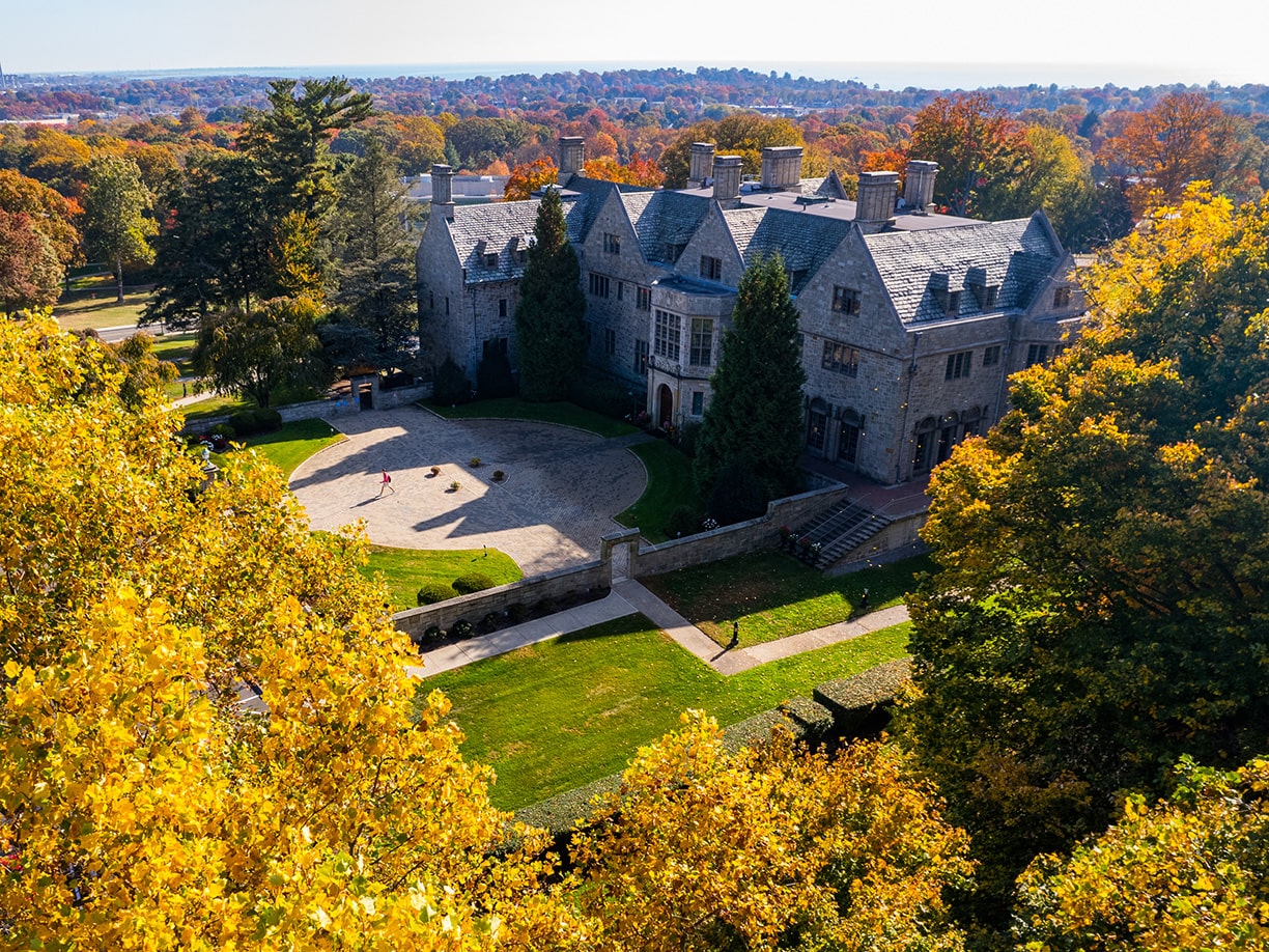 Bellarmine Hall at Fairfield University campus is enveloped by trees, blending architecture with nature in a tranquil setting.