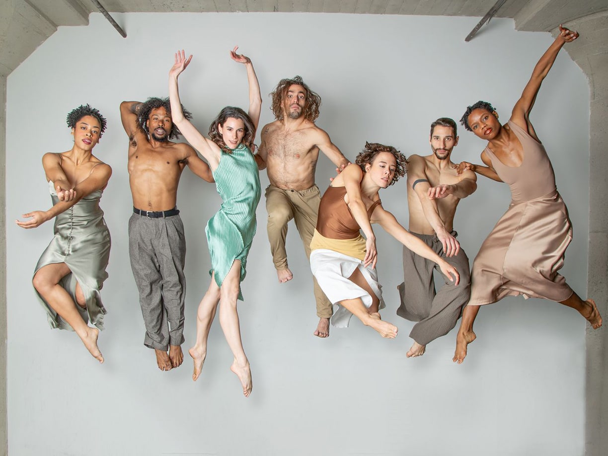 Seven-performer group (BODYTRAFFIC) suspended in the air in various poses.