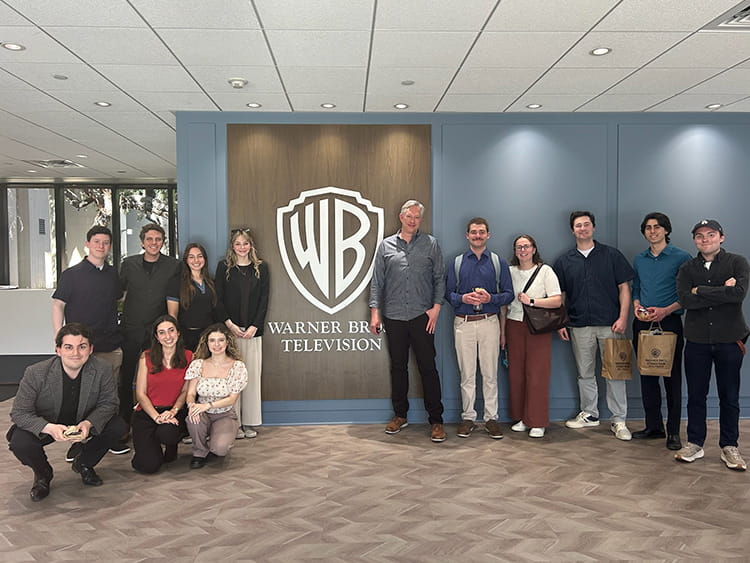 Fairfield Meditz students posing in front of the Warner Bros. logo inside of an executive office.