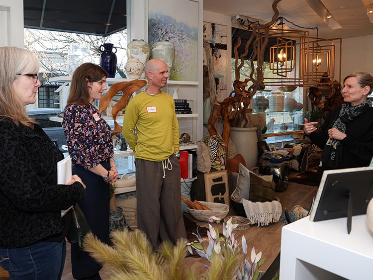 Interior design students learning from a seasoned professional in a highly-decorated room.