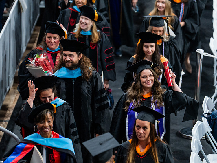 Six Doctorate of Educational Leadership (EdD) graduates standing excitedly together before the Commencement ceremony.