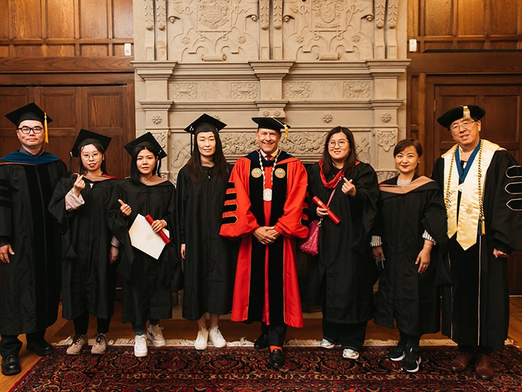 Six graduating students from Fairfield's Shanghai cohort standing proudly with Fairfield Dolan's dean and the University President.