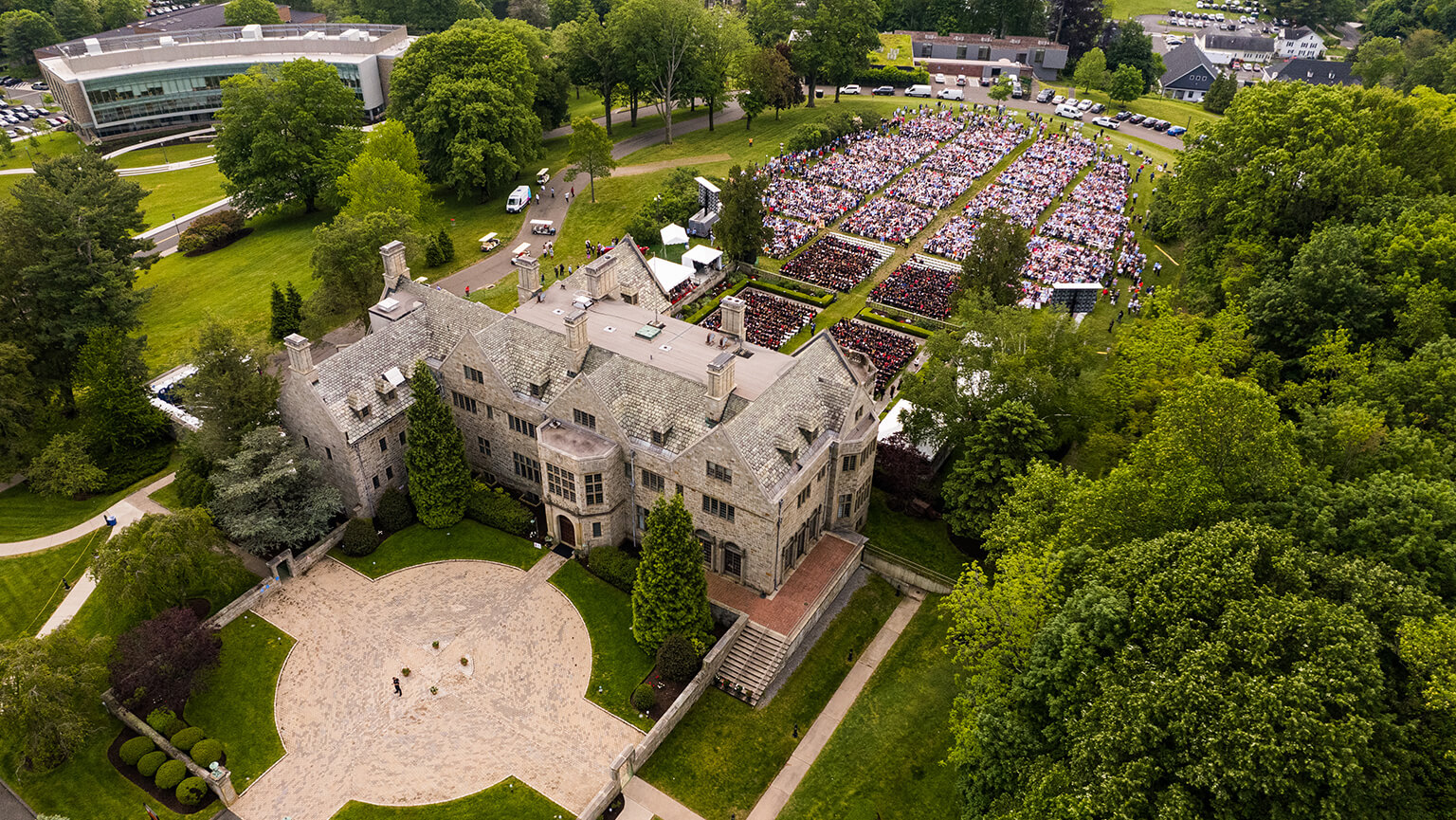 Aerial perspective of Bellarmine Hall enveloped by dense trees, highlighting its impressive architecture and serene setting.