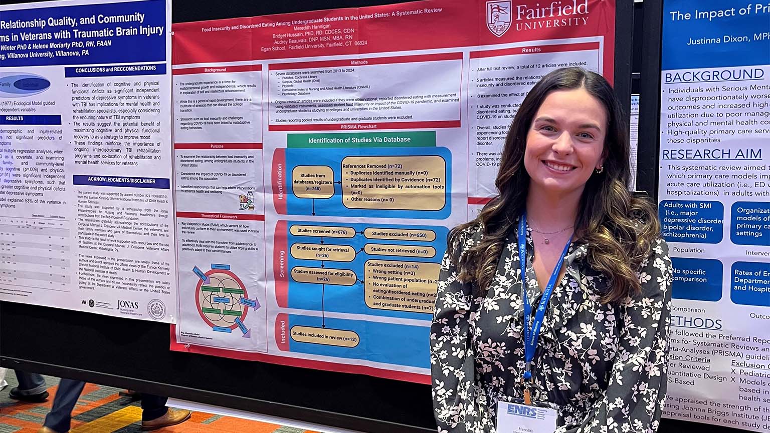 Image of a woman poses next to an informative poster, highlighting details with a friendly expression.