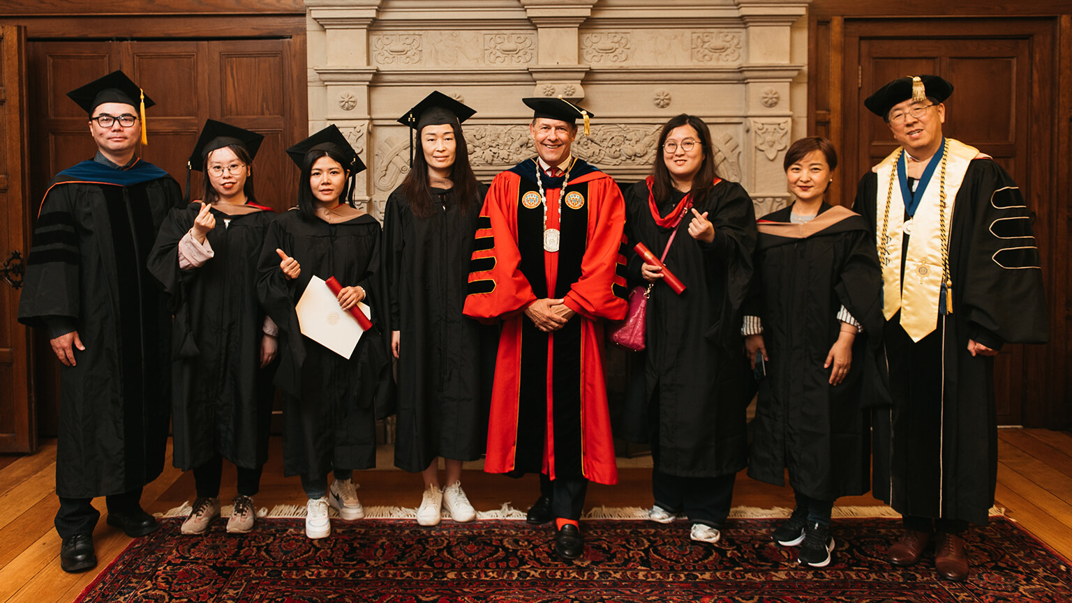 A diverse group of graduates wearing caps and gowns, celebrating their academic achievements together.