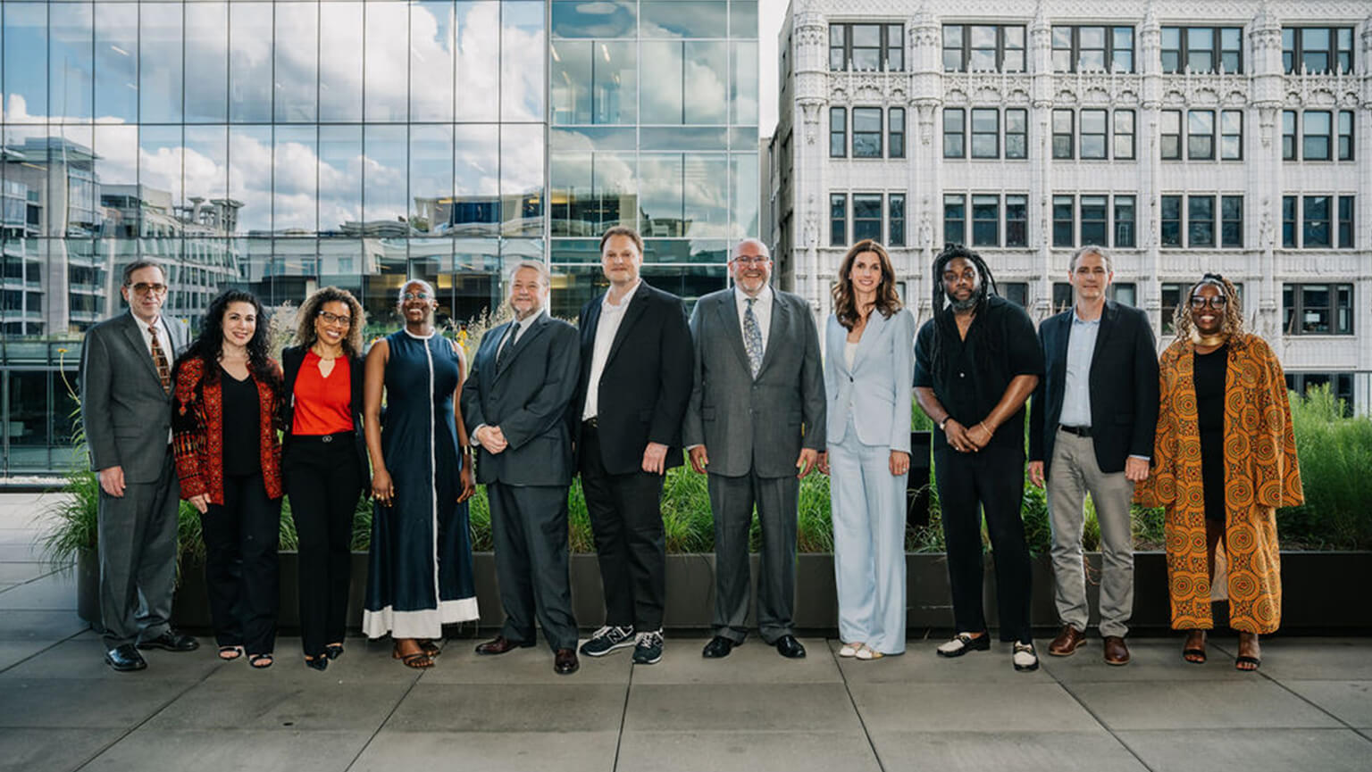 A diverse group of people stands together in front of a building, showcasing camaraderie and community spirit.