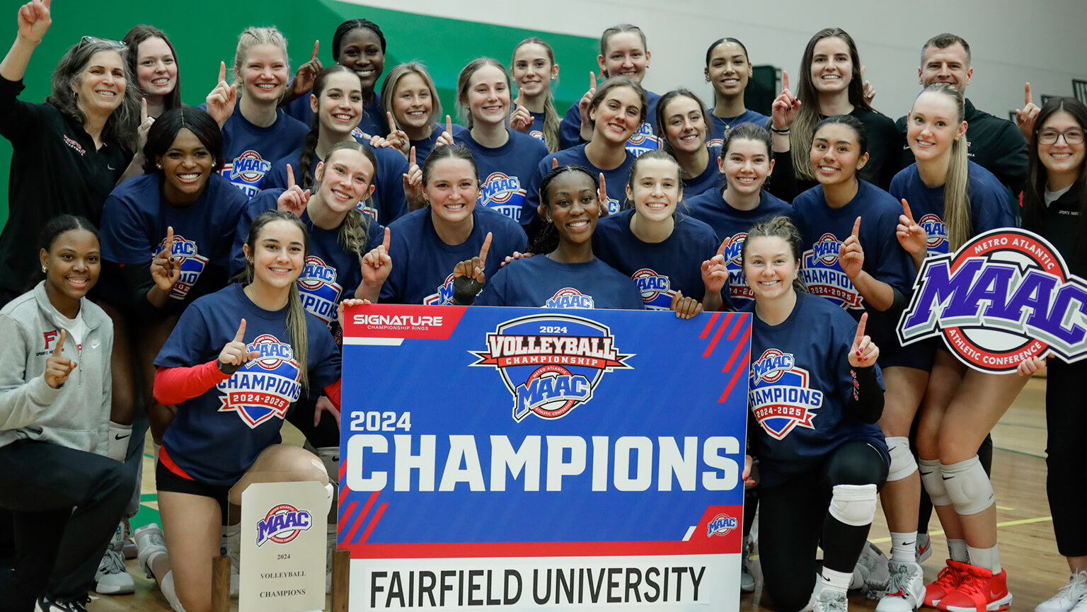 A group photo of the Fairfield University's women's volleyball team holding their trophy, showcasing their achievement and team spirit.
