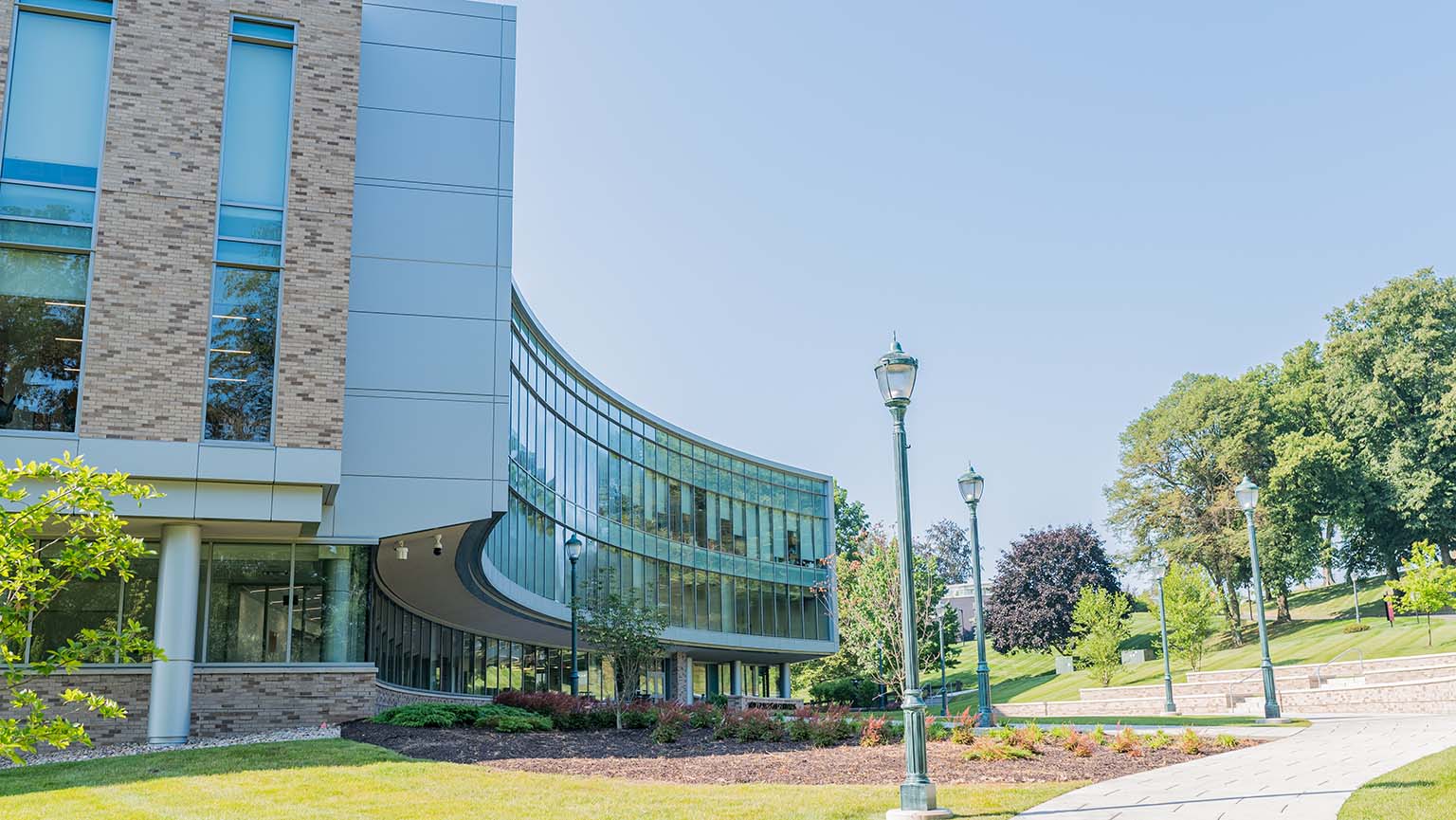 Image of a walkway leading to a building featuring a large glass window, inviting and modern in design.