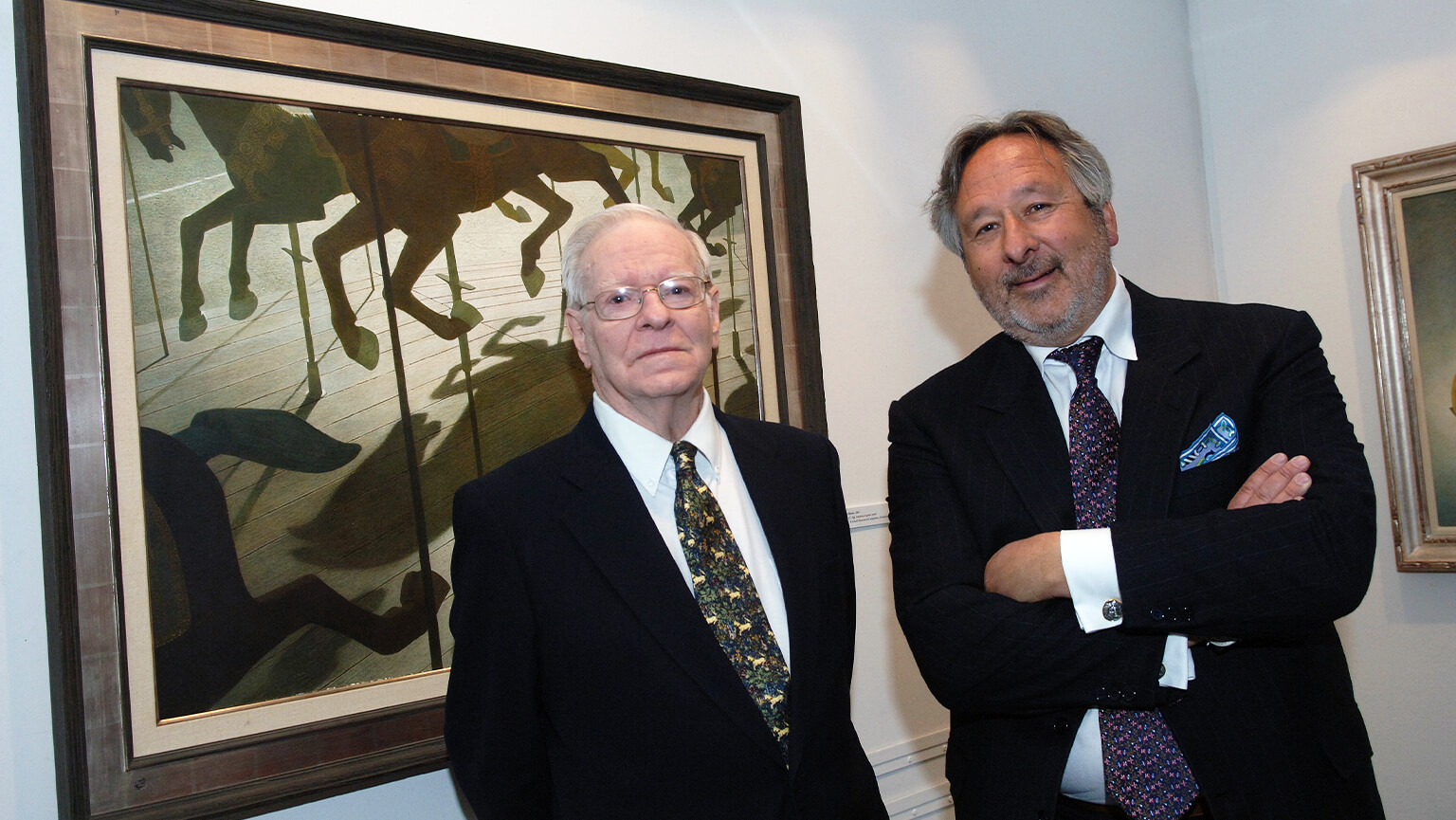 Two men stand side by side in front of a large painting, engaged in conversation and admiring the artwork.
