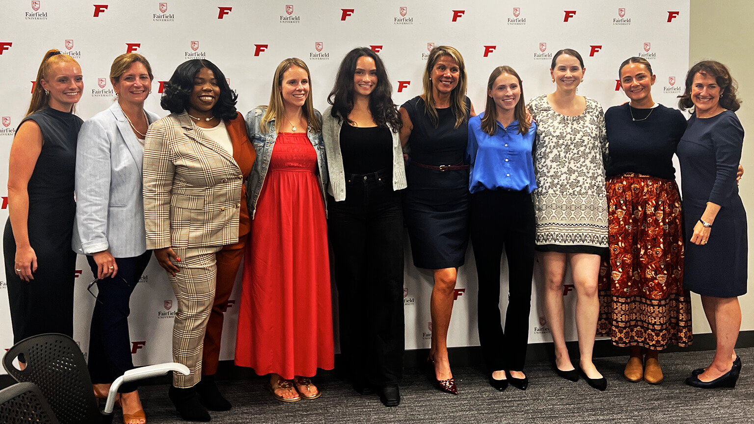 Several women pose together in front of a vibrant wall, showcasing camaraderie and friendship.