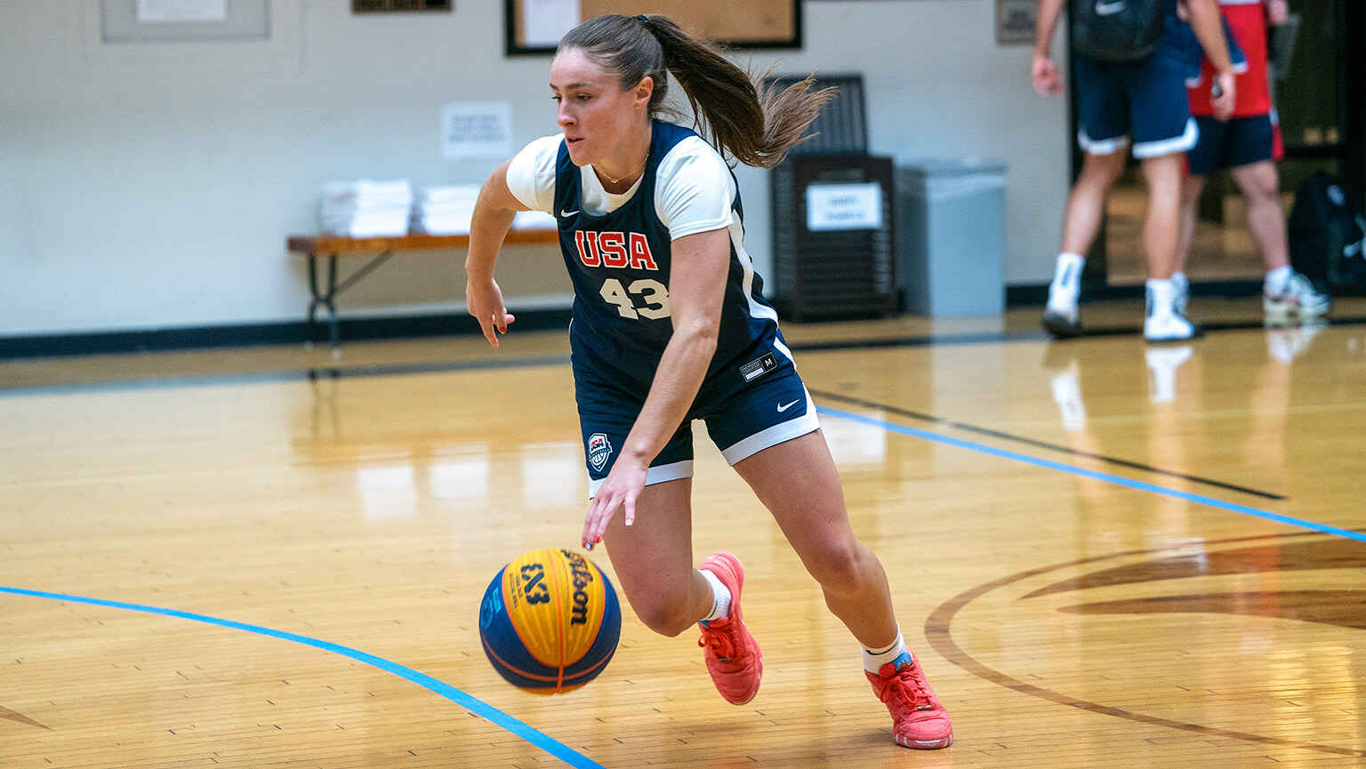 A girl dribbling a basketball on a court, focused and in motion, showcasing her skills and athleticism.