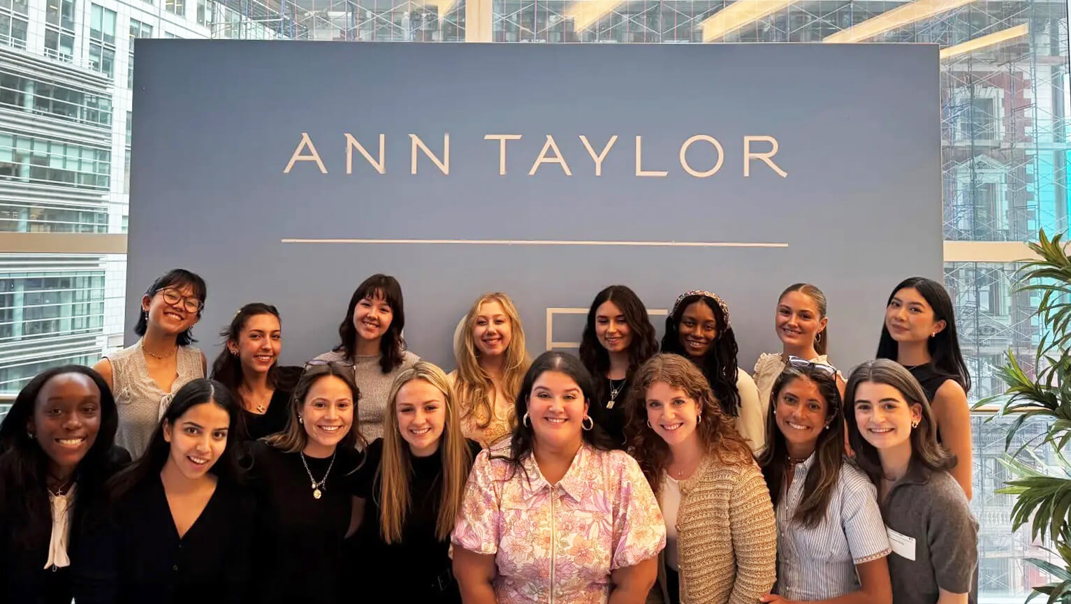 Students pose in front of the Ann Taylor sign.